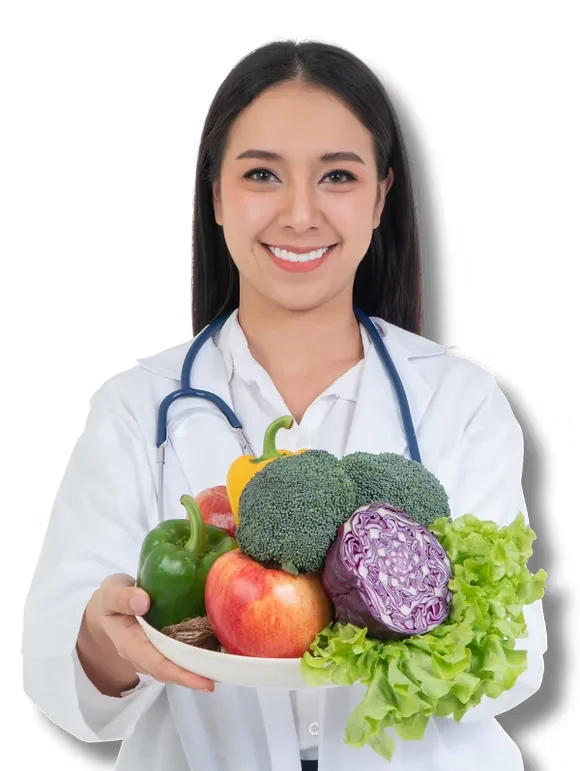 A smiling clinician in a white coat holding a bowl of fresh vegetables